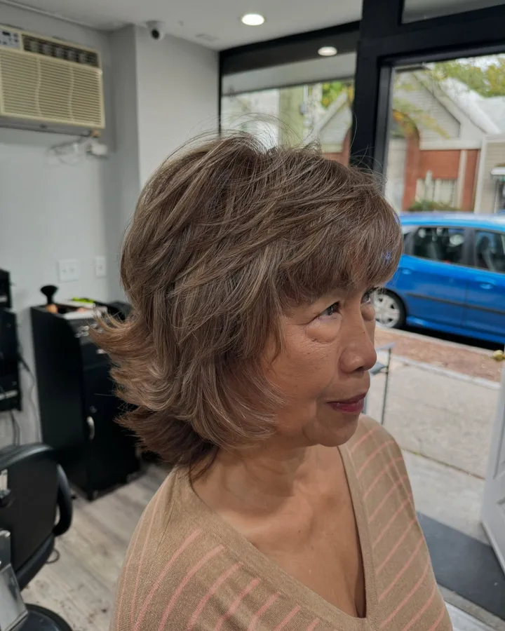 A chin-length layered shag with wispy bangs and soft highlights